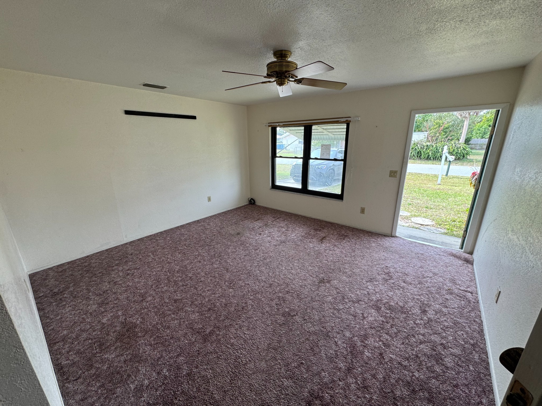 Living room with old carpet before wall repairs and renovation